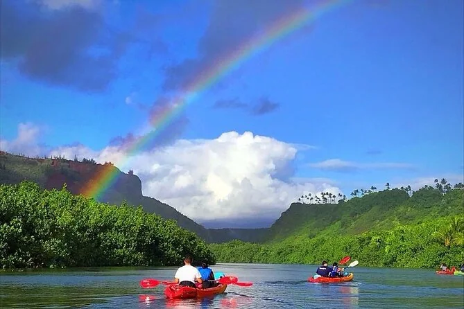 Red tandem kayaks on a wide green river under a rainbow
